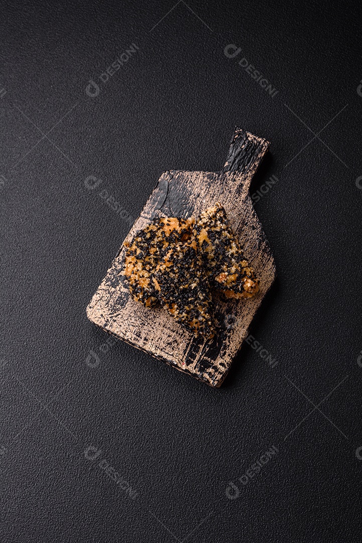 Deliciosos nuggets de frango ou peixe crocantes frescos em um fundo escuro de concreto. Alimentos não saudáveis, fast food