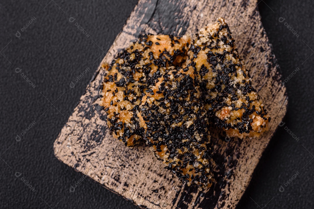 Deliciosos nuggets de frango ou peixe crocantes frescos em um fundo escuro de concreto. Alimentos não saudáveis, fast food