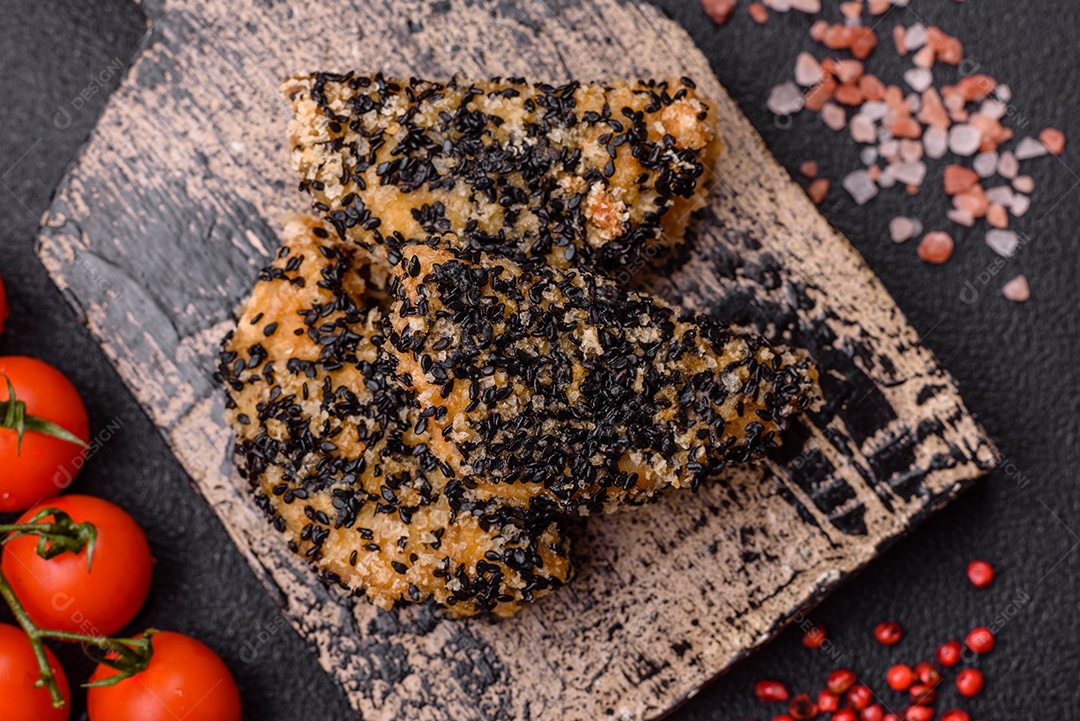 Deliciosos nuggets de frango ou peixe crocantes frescos em um fundo escuro de concreto. Alimentos não saudáveis, fast food