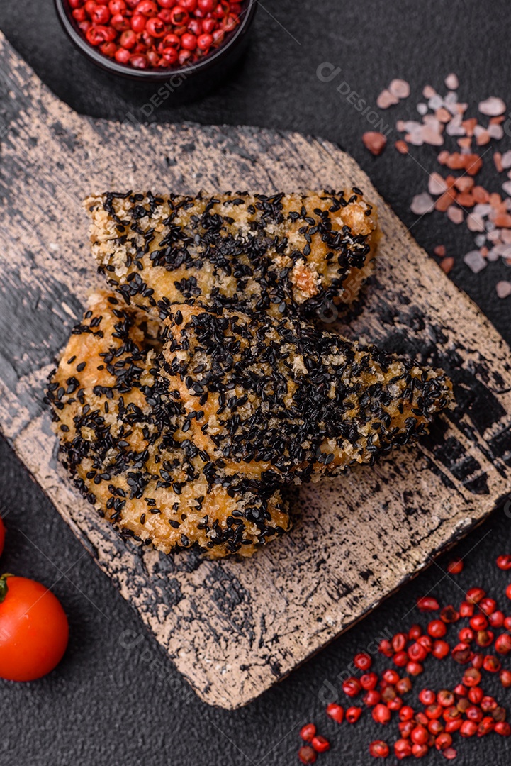 Deliciosos nuggets de frango ou peixe crocantes frescos em um fundo escuro de concreto. Alimentos não saudáveis, fast food