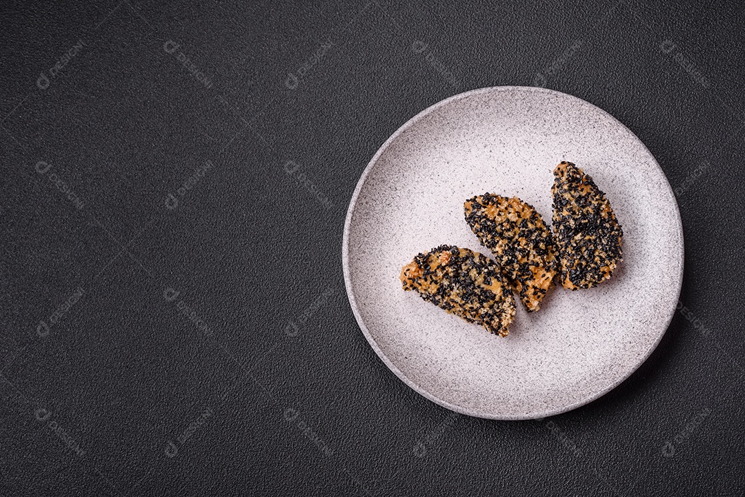 Deliciosos nuggets de frango ou peixe crocantes frescos em um fundo escuro de concreto. Alimentos não saudáveis, fast food