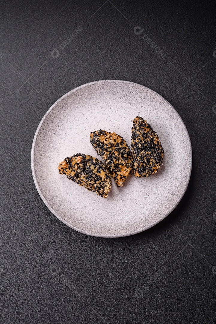 Deliciosos nuggets de frango ou peixe crocantes frescos em um fundo escuro de concreto. Alimentos não saudáveis, fast food