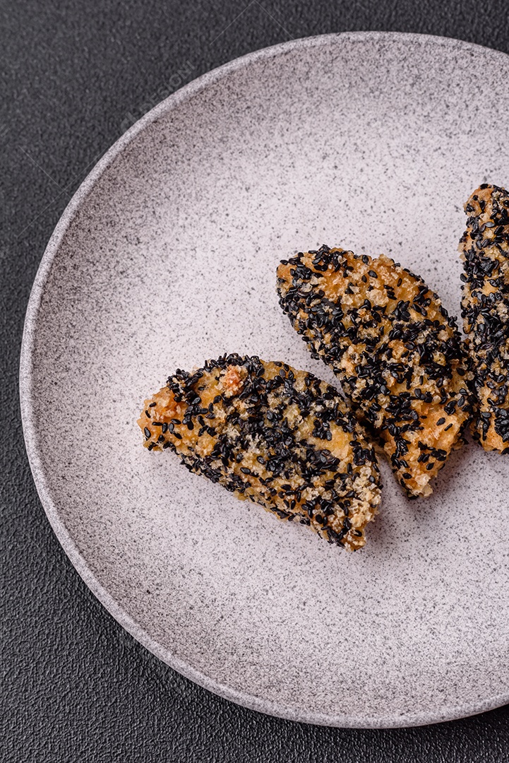 Deliciosos nuggets de frango ou peixe crocantes frescos em um fundo escuro de concreto. Alimentos não saudáveis, fast food