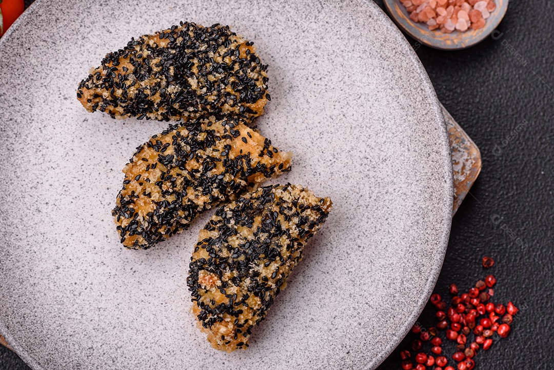 Deliciosos nuggets de frango ou peixe crocantes frescos em um fundo escuro de concreto. Alimentos não saudáveis, fast food