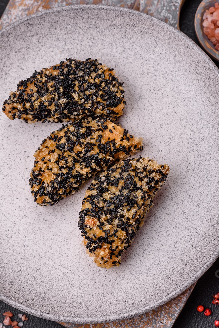 Deliciosos nuggets de frango ou peixe crocantes frescos em um fundo escuro de concreto. Alimentos não saudáveis, fast food