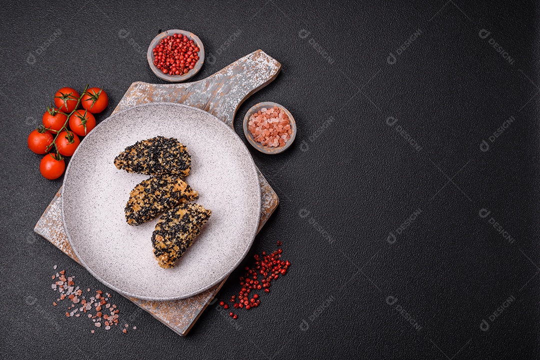 Deliciosos nuggets de frango ou peixe crocantes frescos em um fundo escuro de concreto. Alimentos não saudáveis, fast food