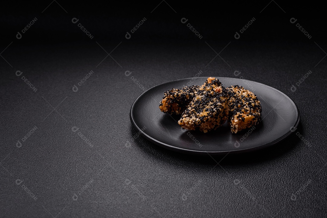 Deliciosos nuggets de frango ou peixe crocantes frescos em um fundo escuro de concreto. Alimentos não saudáveis, fast food