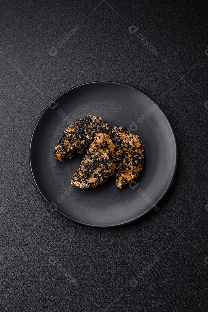 Deliciosos nuggets de frango ou peixe crocantes frescos em um fundo escuro de concreto. Alimentos não saudáveis, fast food