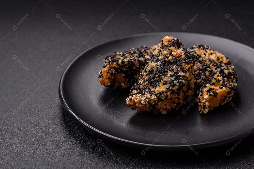 Deliciosos nuggets de frango ou peixe crocantes frescos em um fundo escuro de concreto. Alimentos não saudáveis, fast food