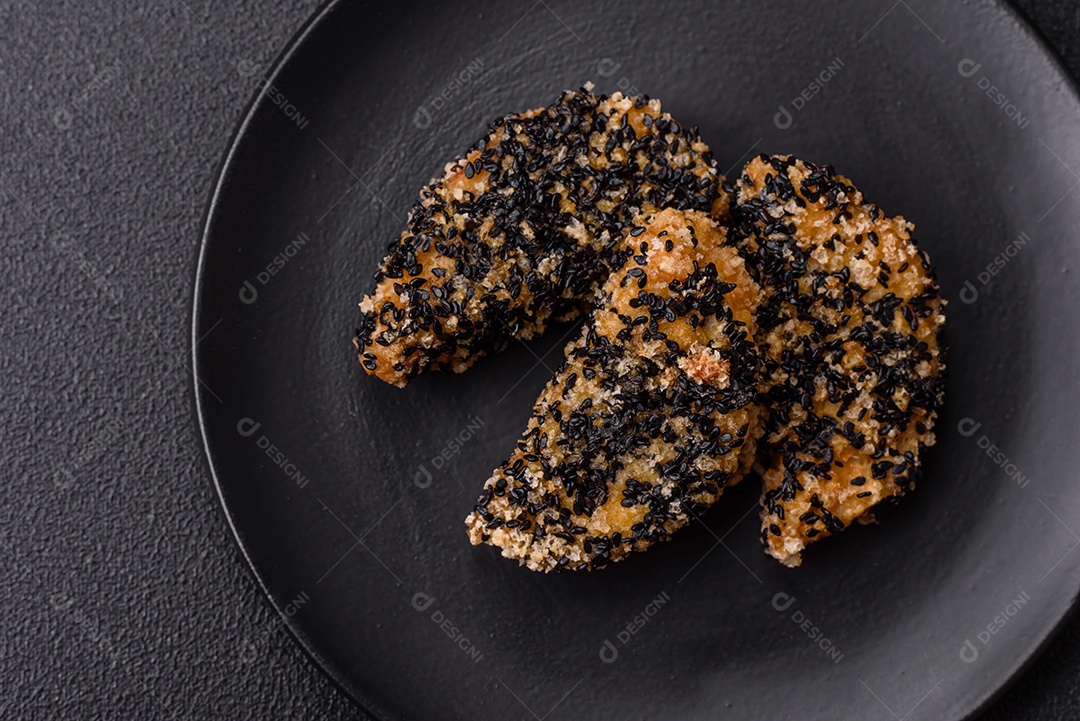 Deliciosos nuggets de frango ou peixe crocantes frescos em um fundo escuro de concreto. Alimentos não saudáveis, fast food