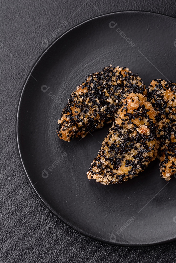 Deliciosos nuggets de frango ou peixe crocantes frescos em um fundo escuro de concreto. Alimentos não saudáveis, fast food