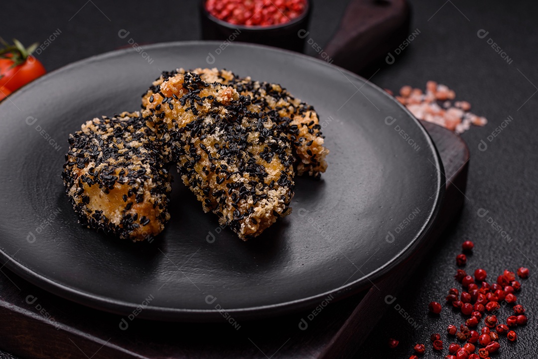 Deliciosos nuggets de frango ou peixe crocantes frescos em um fundo escuro de concreto. Alimentos não saudáveis, fast food