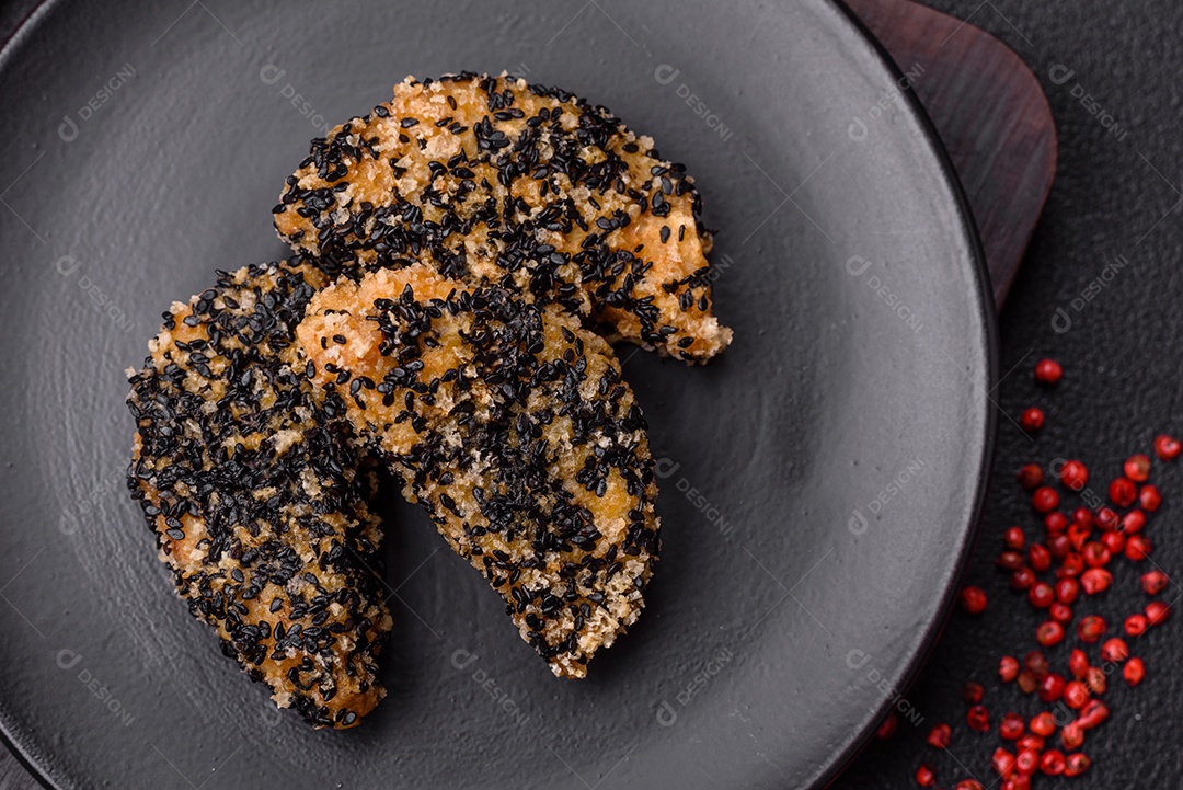 Deliciosos nuggets de frango ou peixe crocantes frescos em um fundo escuro de concreto. Alimentos não saudáveis, fast food