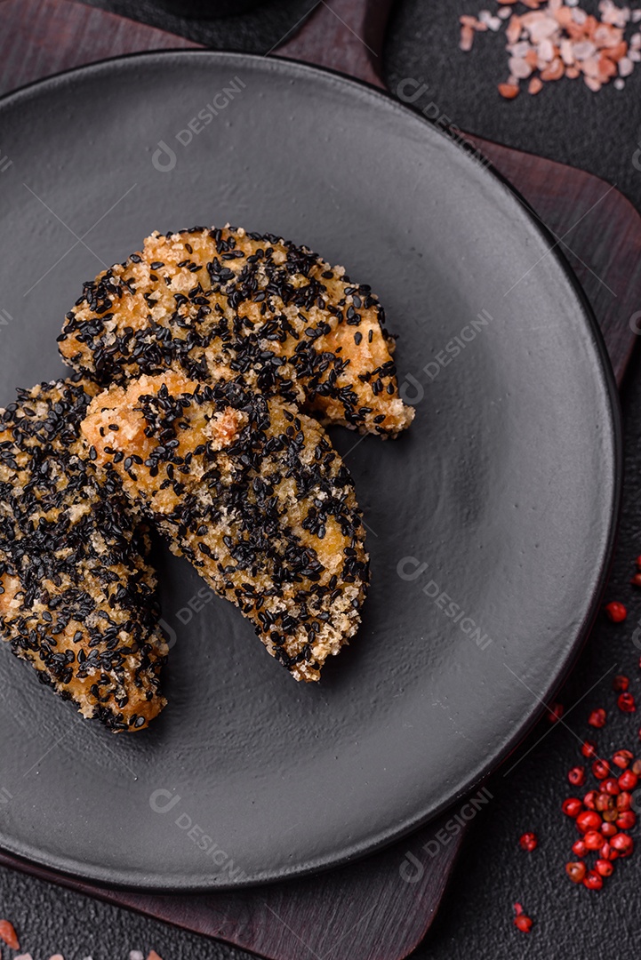 Deliciosos nuggets de frango ou peixe crocantes frescos em um fundo escuro de concreto. Alimentos não saudáveis, fast food