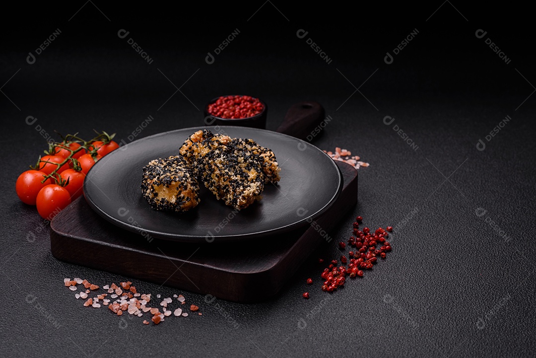 Deliciosos nuggets de frango ou peixe crocantes frescos em um fundo escuro de concreto. Alimentos não saudáveis, fast food