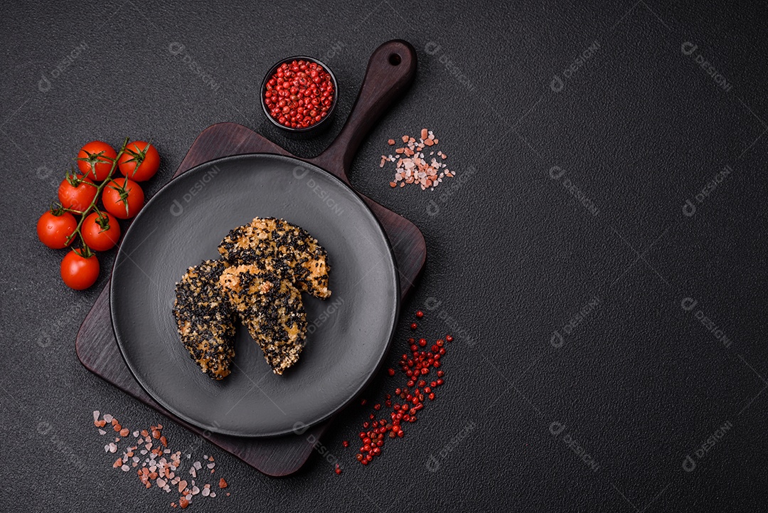 Deliciosos nuggets de frango ou peixe crocantes frescos em um fundo escuro de concreto. Alimentos não saudáveis, fast food