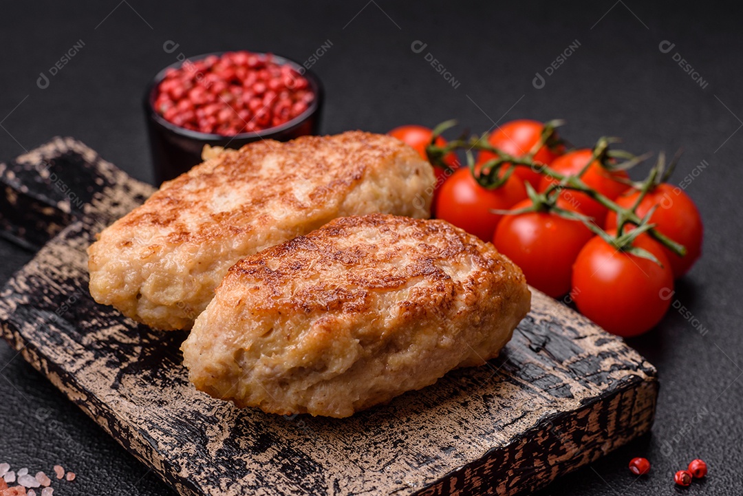 Deliciosas costeletas de peixe picado frito fresco com especiarias e ervas sobre um fundo escuro de concreto