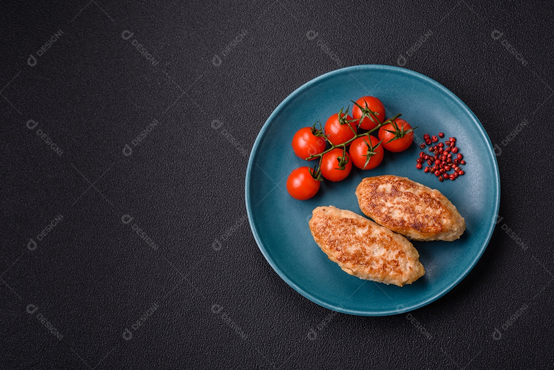 Deliciosas costeletas de peixe picado frito fresco com especiarias e ervas sobre um fundo escuro de concreto