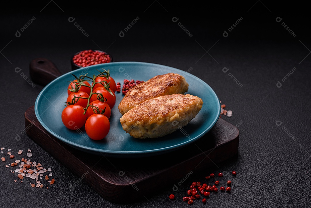 Deliciosas costeletas de peixe picado frito fresco com especiarias e ervas sobre um fundo escuro de concreto