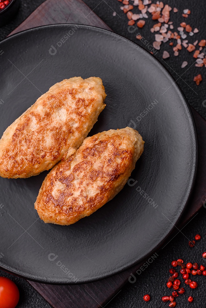 Deliciosas costeletas de peixe picado frito fresco com especiarias e ervas sobre um fundo escuro de concreto