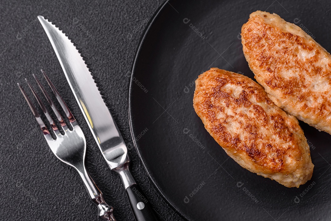 Deliciosas costeletas de peixe picado frito fresco com especiarias e ervas sobre um fundo escuro de concreto