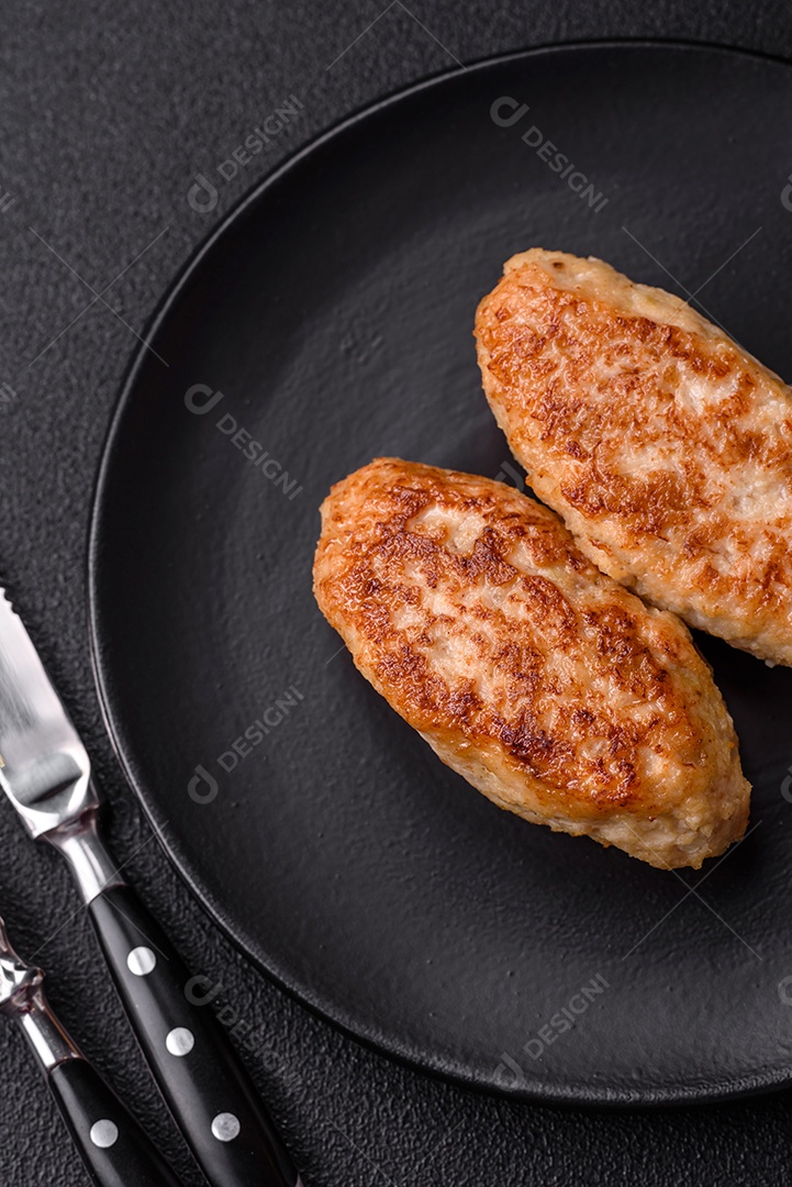 Deliciosas costeletas de peixe picado frito fresco com especiarias e ervas sobre um fundo escuro de concreto