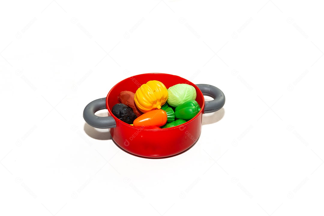 Brinquedo infantil, panela com vegetais plásticos isolados em fundo branco