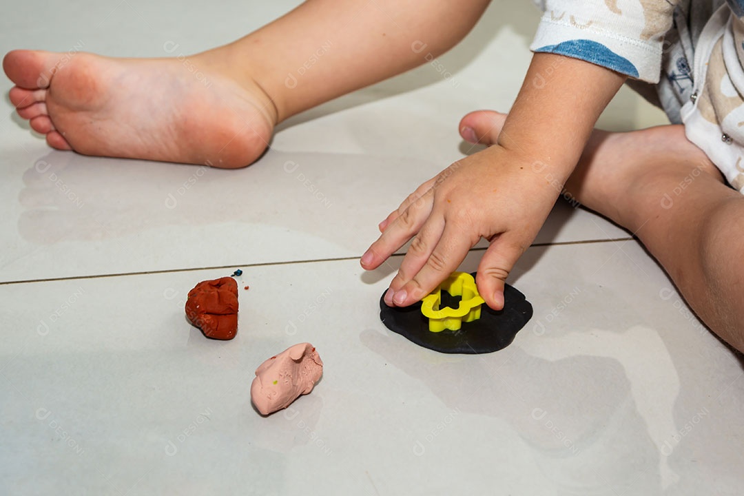 Criança brincando em casa, de pijama, muitos brinquedos bagunçados