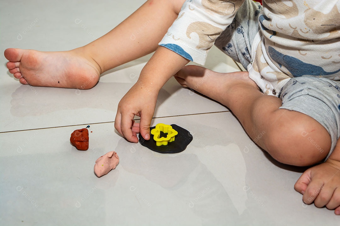 Criança brincando em casa, de pijama, muitos brinquedos bagunçados
