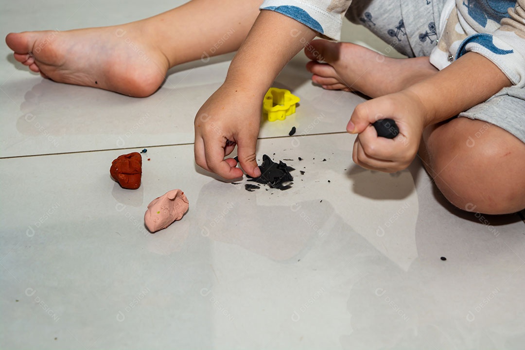 Criança brincando em casa, de pijama, muitos brinquedos bagunçados