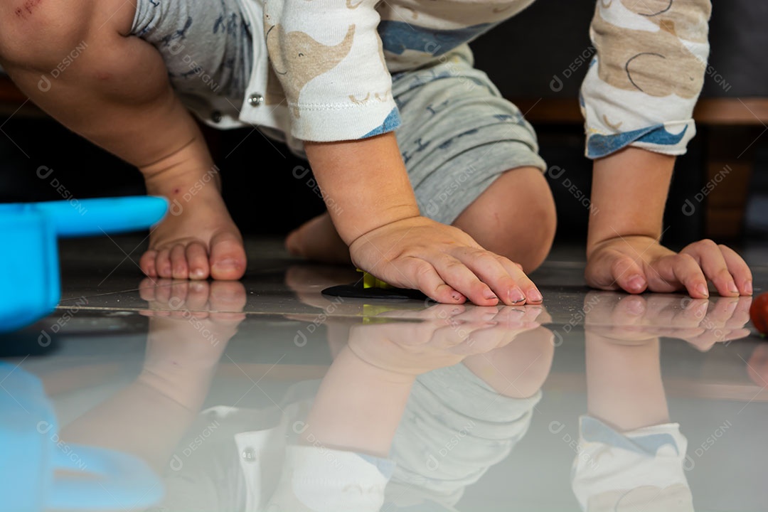Criança brincando com massinha no chão em casa