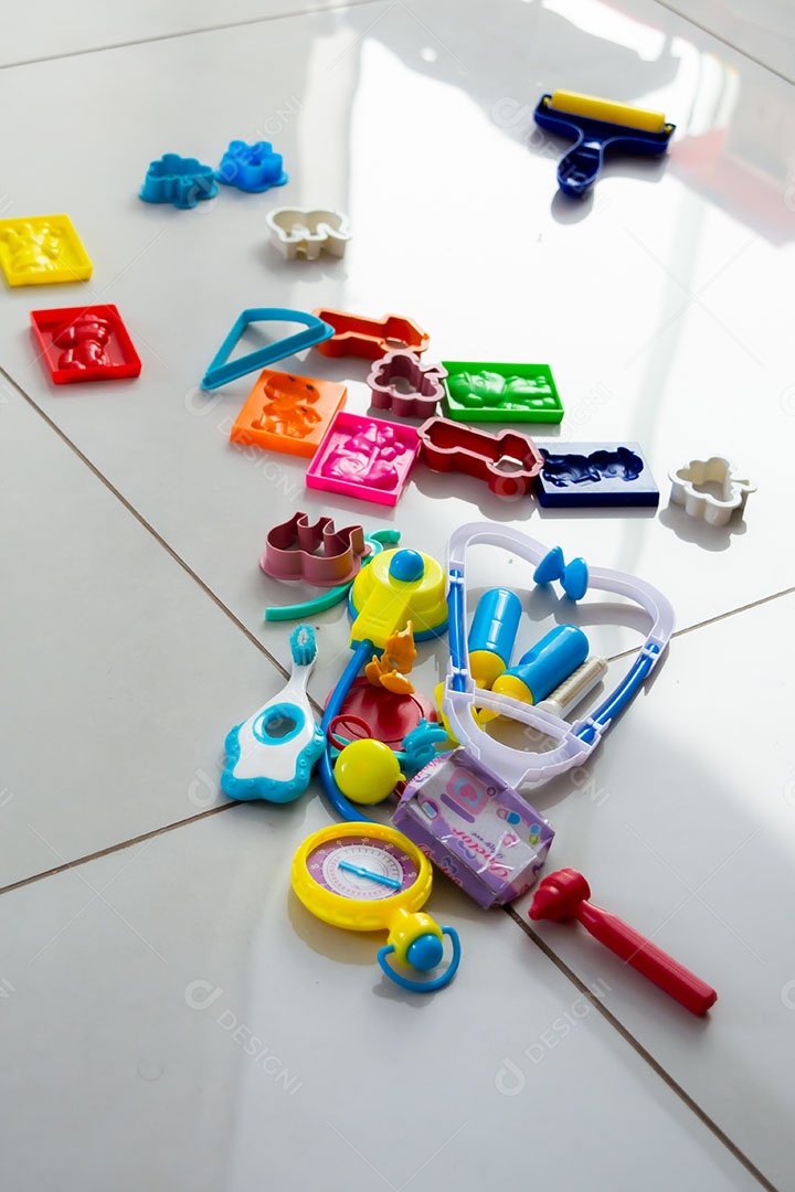 Chão bagunçado com muitos brinquedos infantis espalhados pela casa