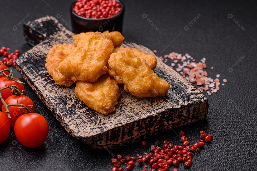 Deliciosos nuggets de frango crocantes frescos em um fundo escuro de concreto. Alimentos não saudáveis, fast food