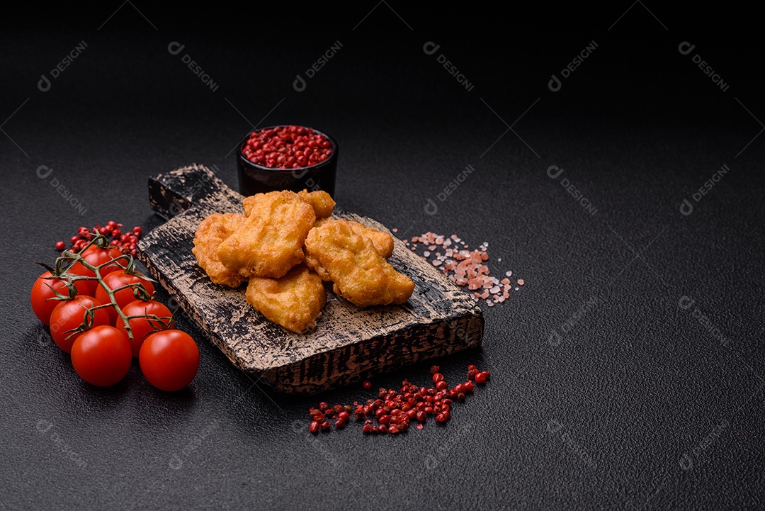 Deliciosos nuggets de frango crocantes frescos em um fundo escuro de concreto. Alimentos não saudáveis, fast food