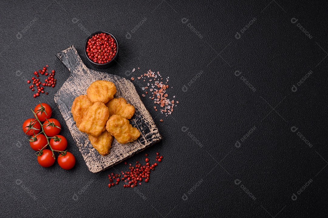 Deliciosos nuggets de frango crocantes frescos em um fundo escuro de concreto. Alimentos não saudáveis, fast food