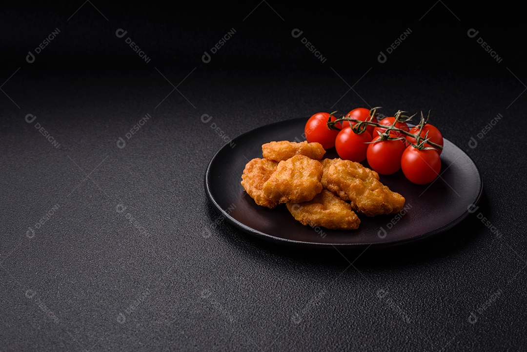 Deliciosos nuggets de frango crocantes frescos em um fundo escuro de concreto. Alimentos não saudáveis, fast food