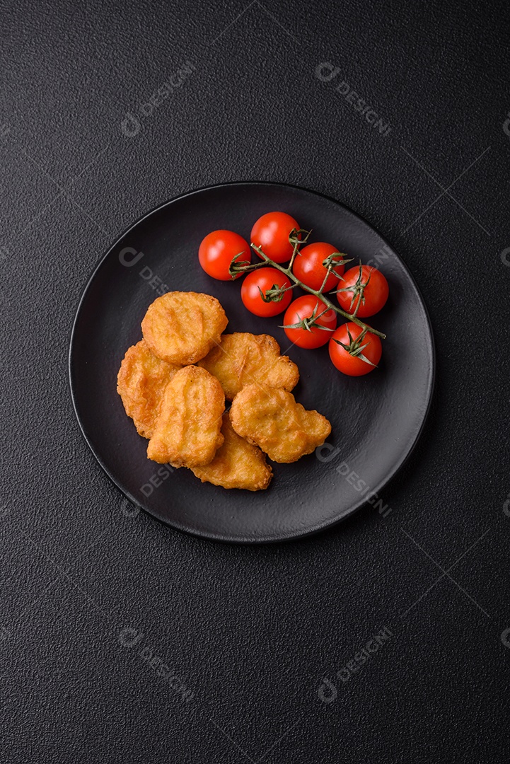 Deliciosos nuggets de frango crocantes frescos em um fundo escuro de concreto. Alimentos não saudáveis, fast food