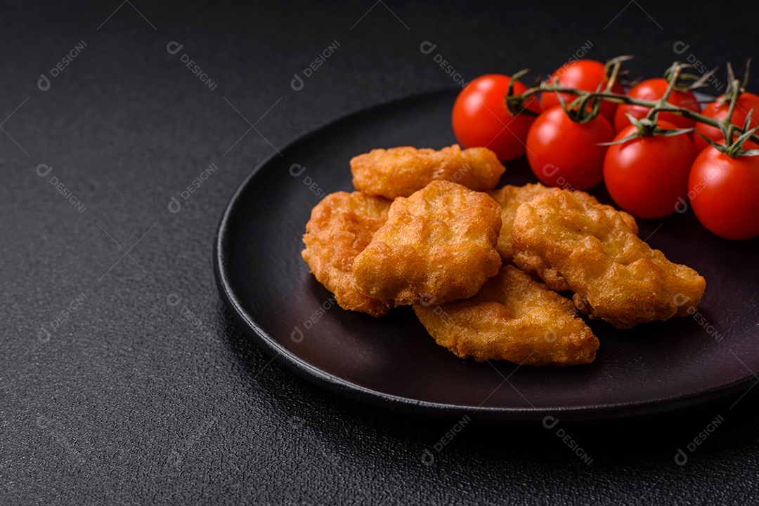 Deliciosos nuggets de frango crocantes frescos em um fundo escuro de concreto. Alimentos não saudáveis, fast food