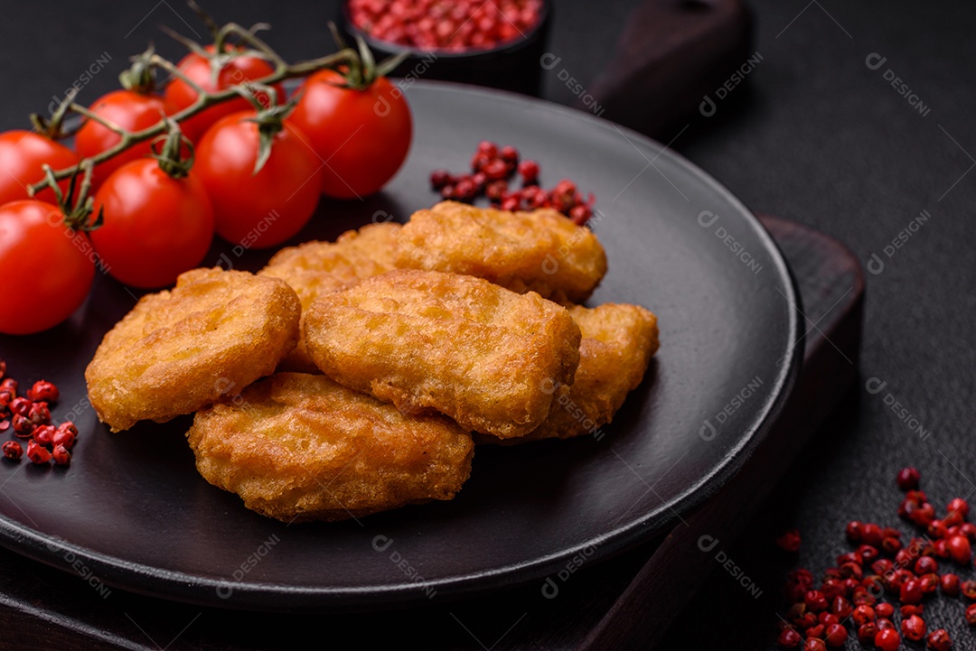 Deliciosos nuggets de frango crocantes frescos em um fundo escuro de concreto. Alimentos não saudáveis, fast food