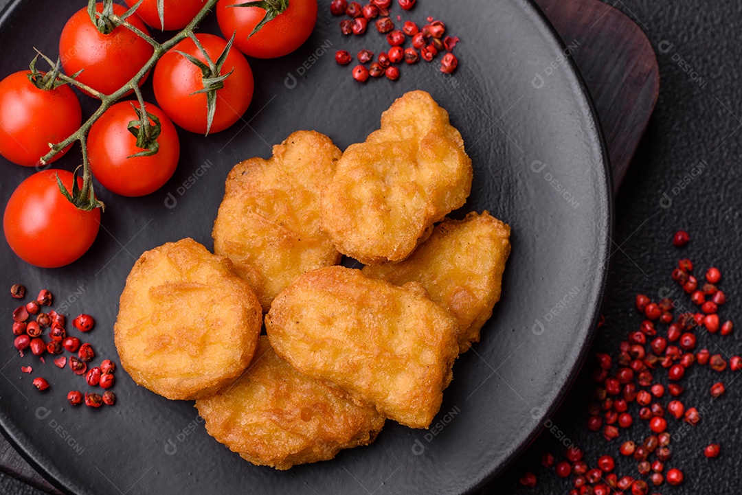 Deliciosos nuggets de frango crocantes frescos em um fundo escuro de concreto. Alimentos não saudáveis, fast food