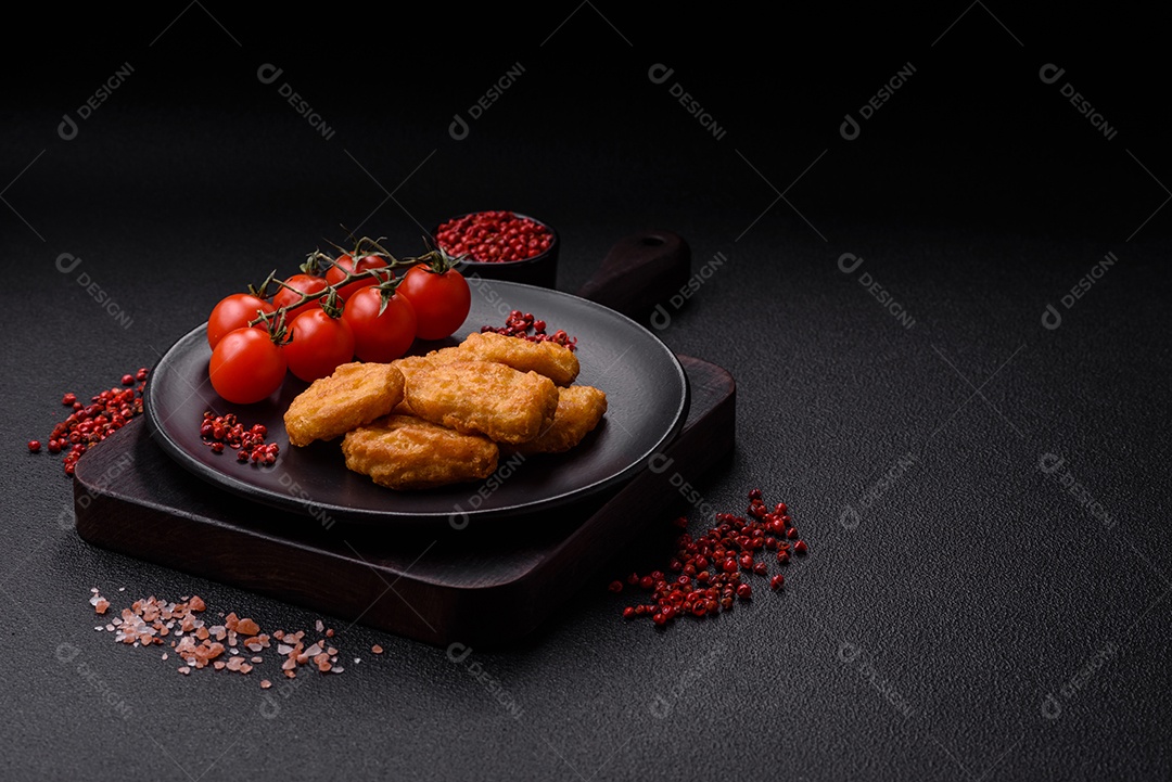 Deliciosos nuggets de frango crocantes frescos em um fundo escuro de concreto. Alimentos não saudáveis, fast food