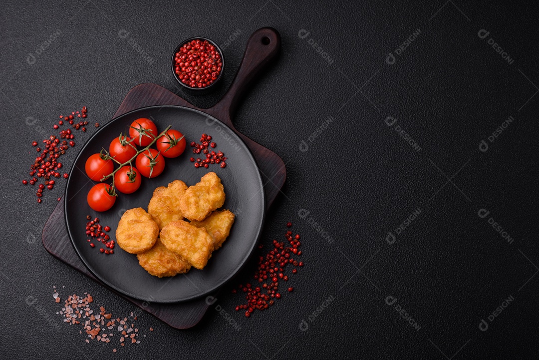 Deliciosos nuggets de frango crocantes frescos em um fundo escuro de concreto. Alimentos não saudáveis, fast food