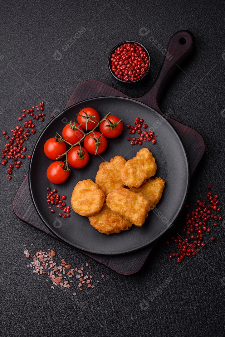 Deliciosos nuggets de frango crocantes frescos em um fundo escuro de concreto. Alimentos não saudáveis, fast food