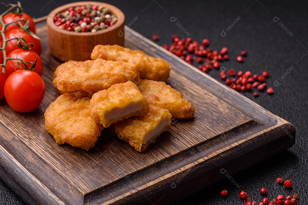 Deliciosos nuggets de frango crocantes frescos em um fundo escuro de concreto. Alimentos não saudáveis, fast food