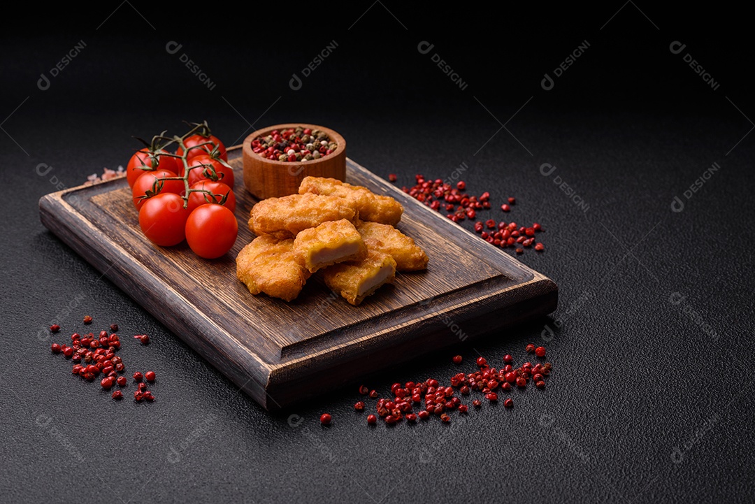 Deliciosos nuggets de frango crocantes frescos em um fundo escuro de concreto. Alimentos não saudáveis, fast food