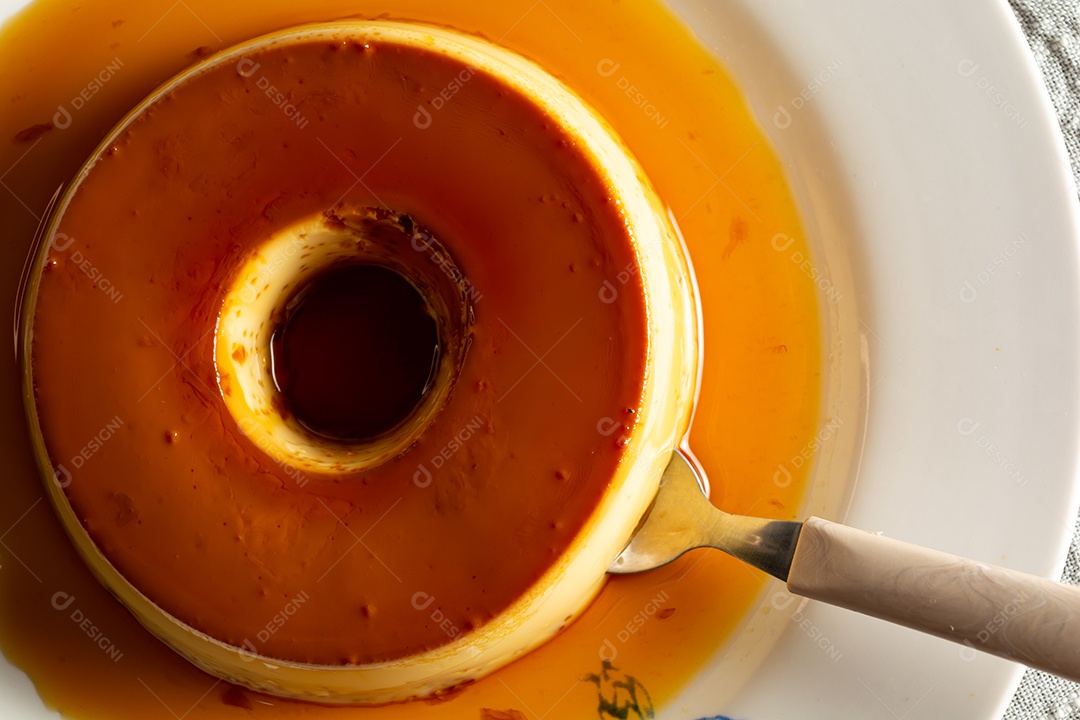 Pudim de leite condensado lindo e saboroso com colher ao lado