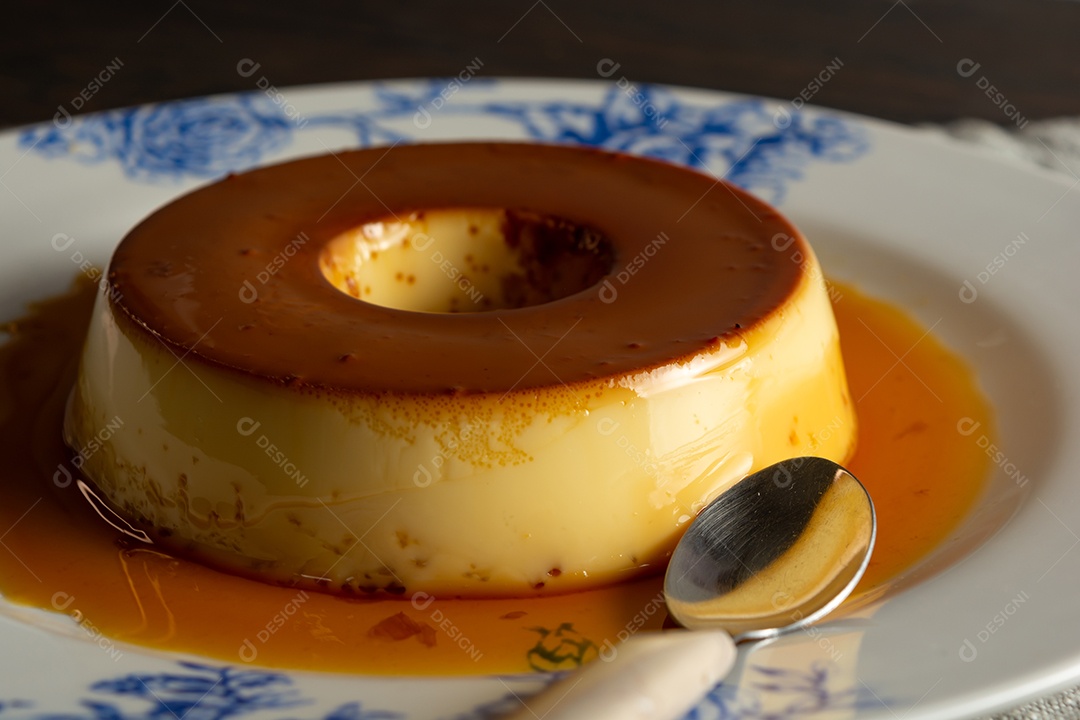 Pudim lindo e saboroso em prato decorado com colher ao lado