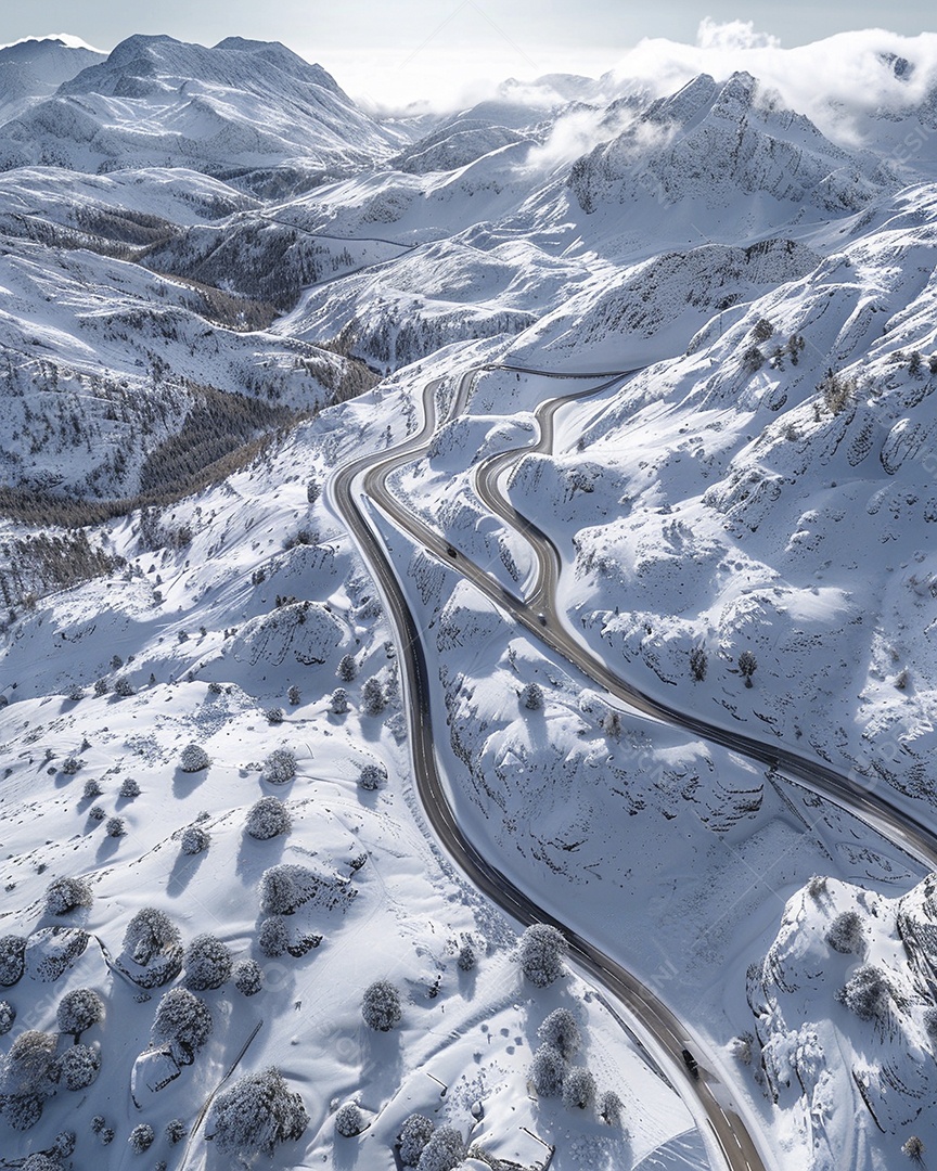 Vista aérea de uma estrada sinuosa nas montanhas com neve