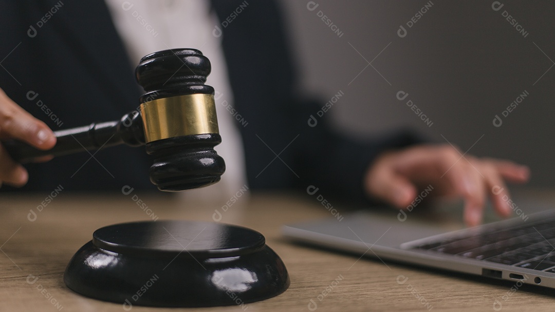 Mulher juíza mão segurando o martelo para bater no bloco de som na sala do tribunal