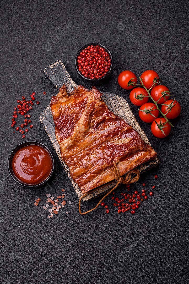 Deliciosas costelas defumadas ou grelhadas com azeitonas, especiarias e ervas sobre fundo escuro de concreto